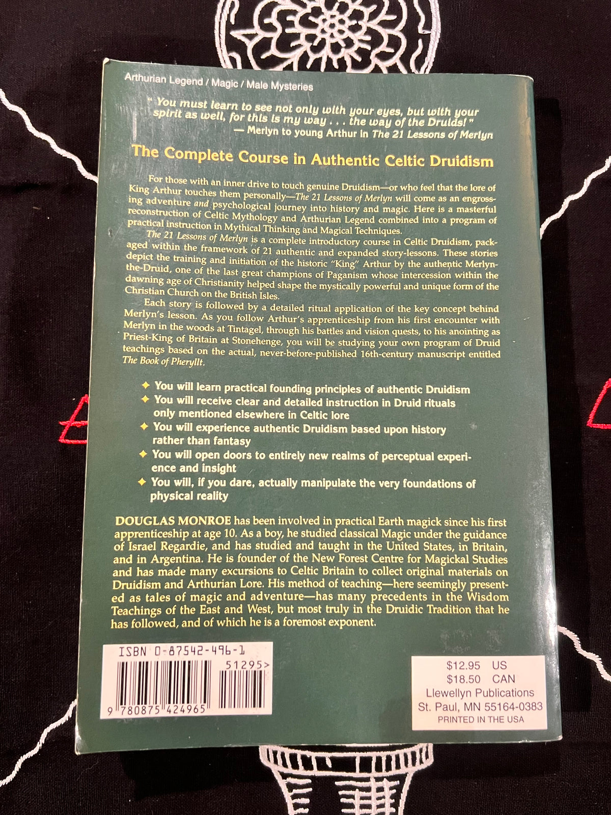 The back cover of a book titled 'The Complete Course in Authentic Celtic Druidism' by Douglas Monki, photographed flat on a black and white patterned fabric background.