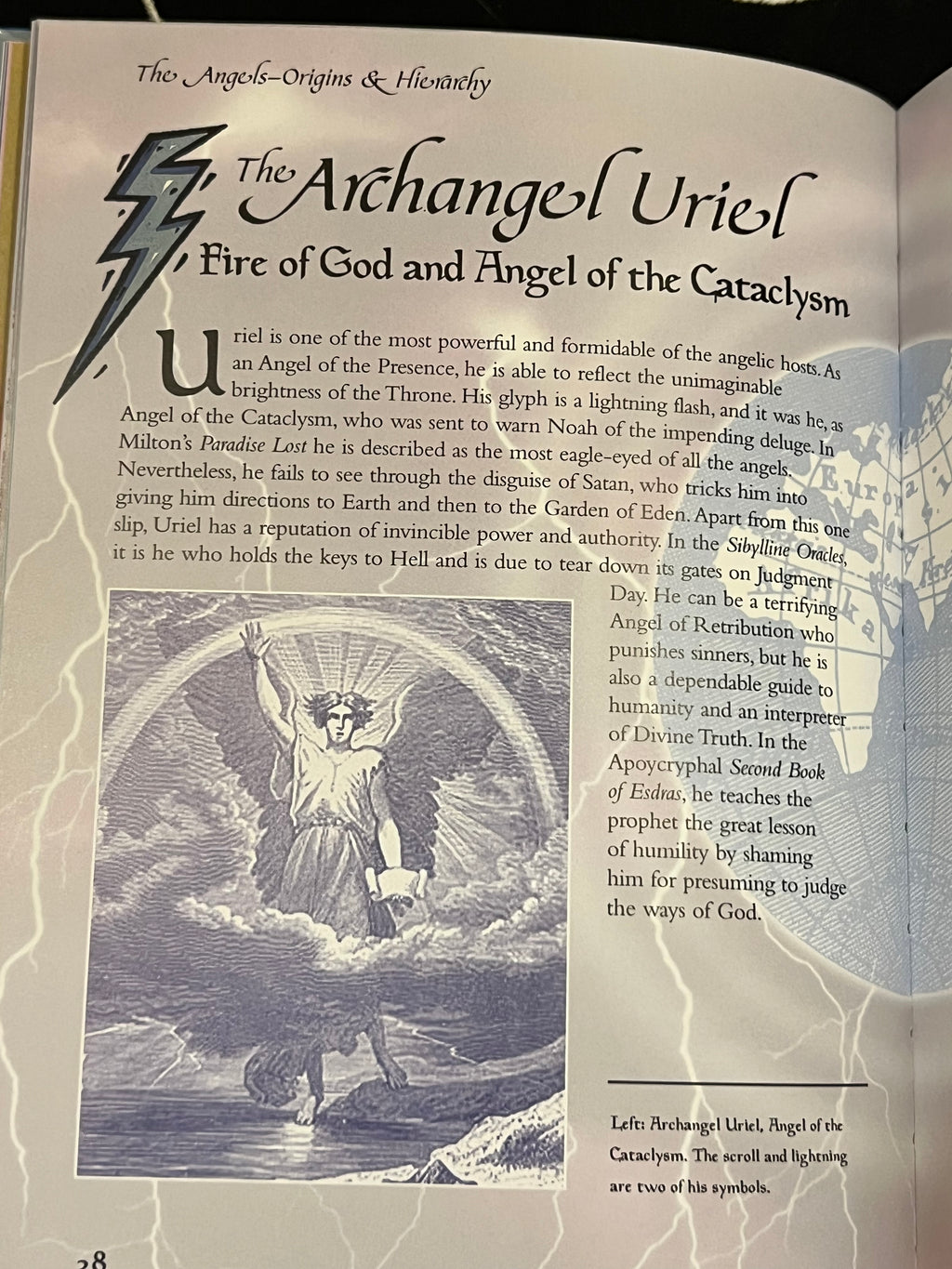 An open book page featuring printed text about 'The Archangel Uriel' with a large lightning bolt illustration and a grayscale angel artwork, photographed against a light neutral background.