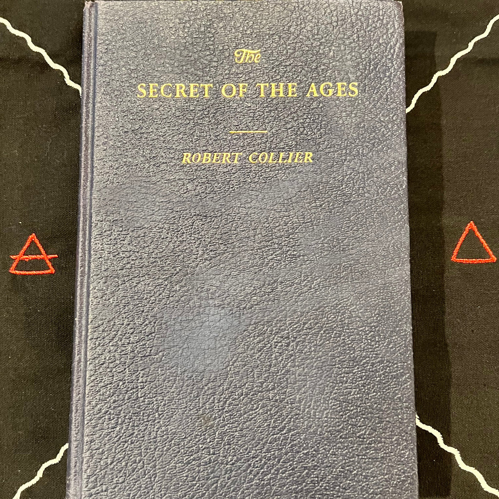 A vintage hardcover book titled 'The Secret of the Ages' by Robert Collier, featuring a textured dark blue-gray cover with gold lettering, displayed on a black background with white line art and red geometric symbols.