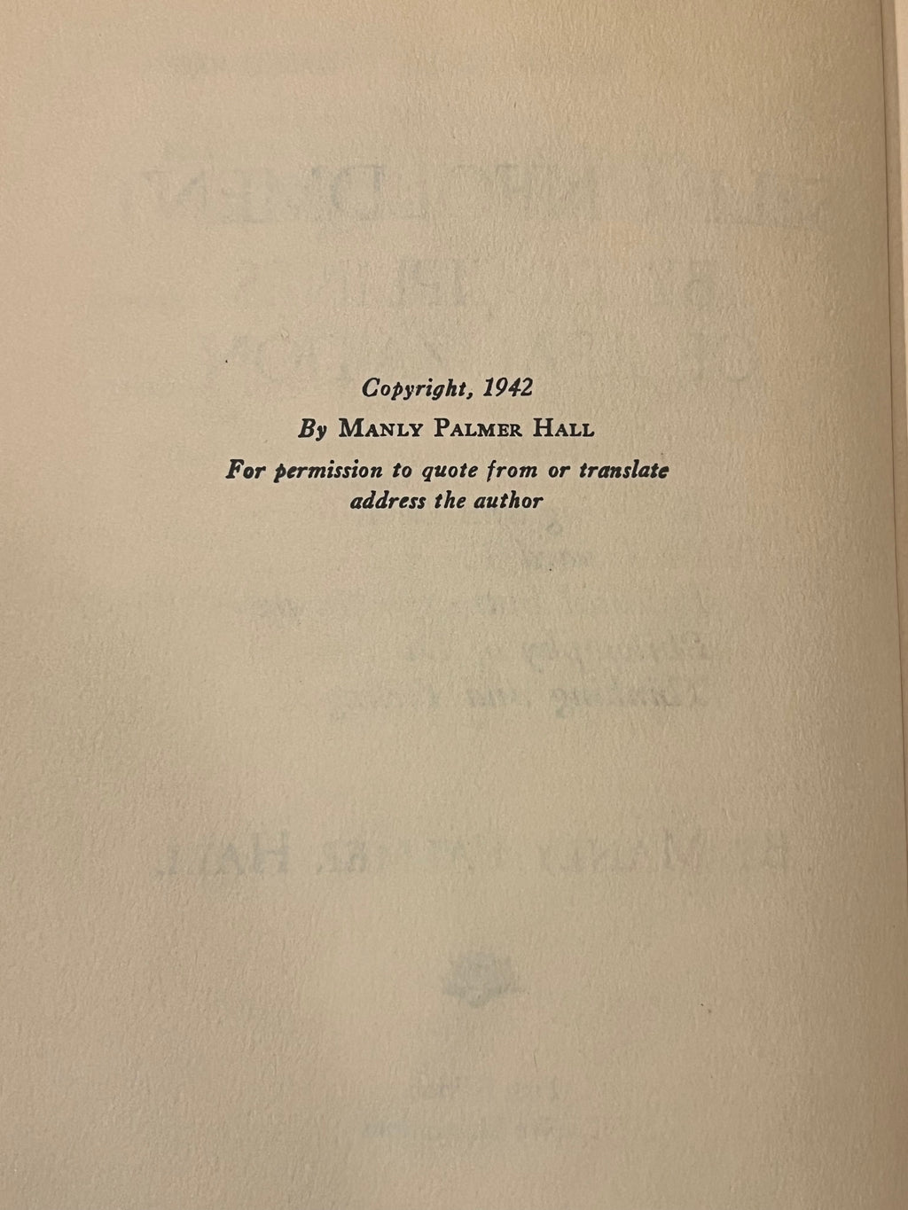 A close-up of an aged beige paper page with black printed text reading 'Copyright, 1942 By Manly Palmer Hall For permission to quote from or translate address the author'.