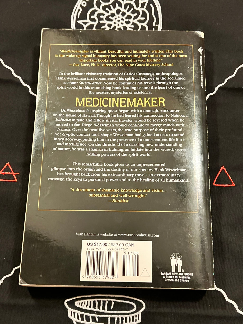 The back cover of the book 'Medicinemaker' by Hank Williams, laid flat on a black background with white tribal-style graphics. The cover is black with gold text and borders, featuring a barcode and customer feedback at the bottom.