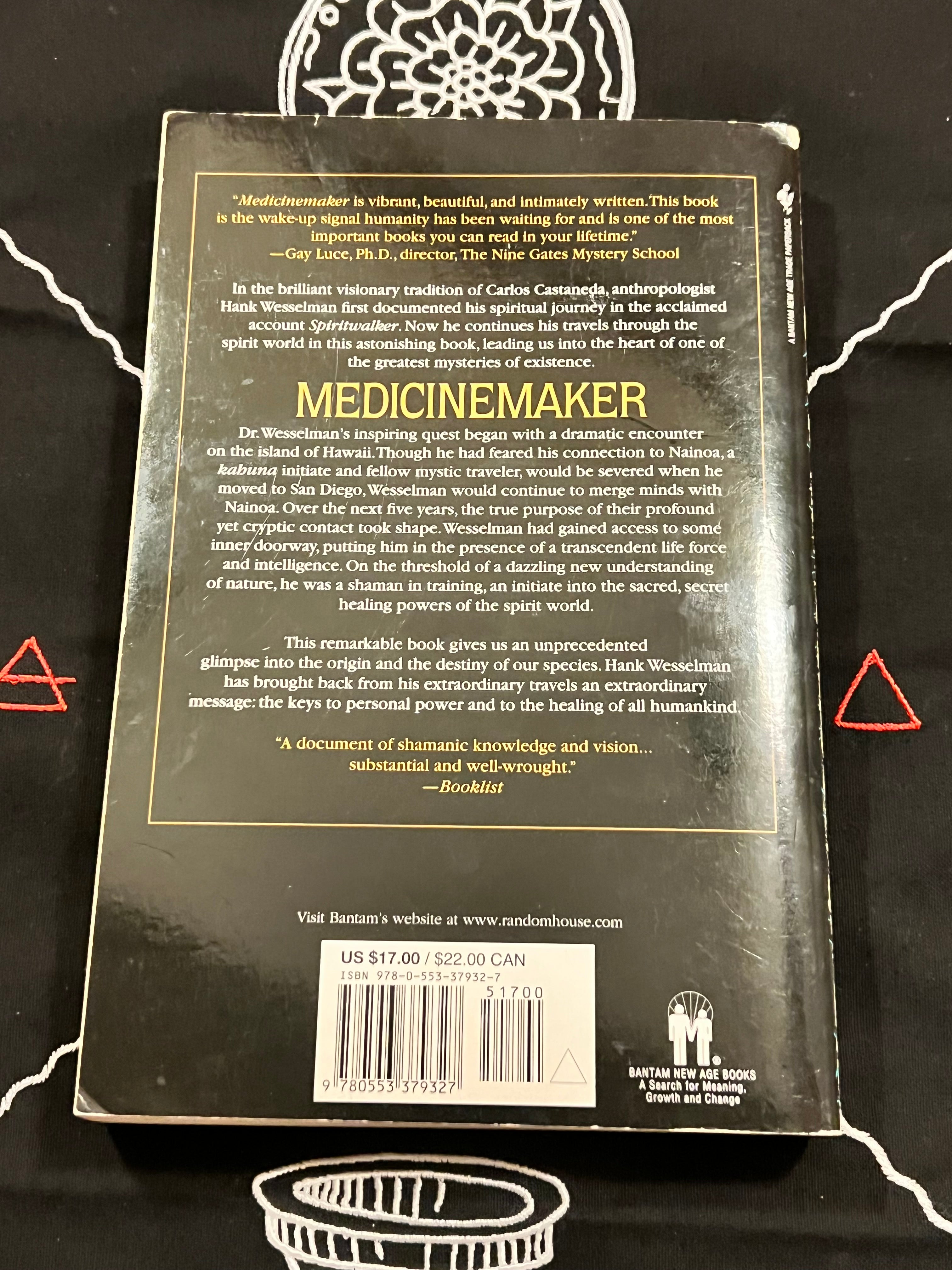 The back cover of the book 'Medicinemaker' by Hank Williams, laid flat on a black background with white tribal-style graphics. The cover is black with gold text and borders, featuring a barcode and customer feedback at the bottom.