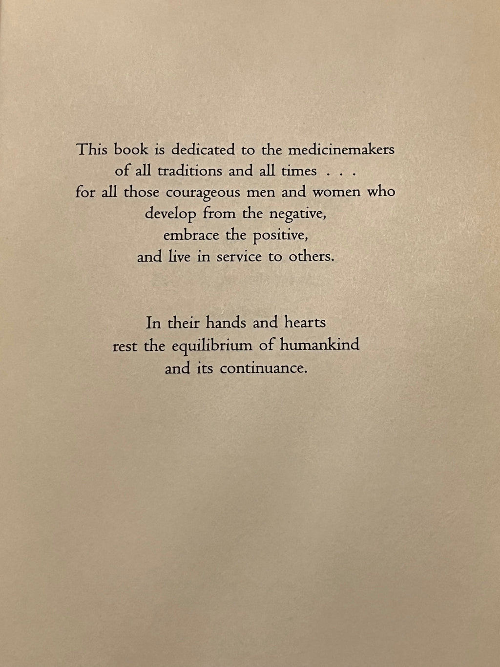 A book page with black serif text on a warm beige background, featuring a dedication paragraph and a second paragraph below it.