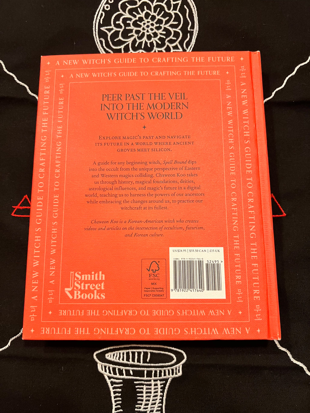 The back cover of the book 'A New Witch's Guide to Crafting the Future' by Smith Street Books, featuring a bright orange-red background with black text and a barcode.