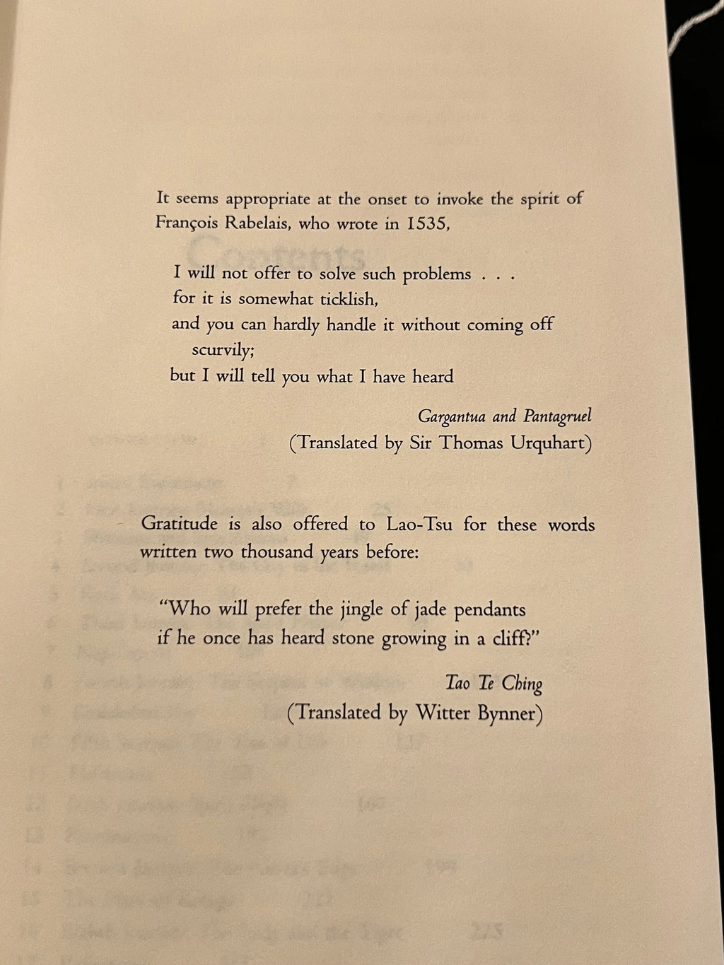 A printed page showing translated philosophical and literary texts on an off-white paper background, photographed against a dark surface.