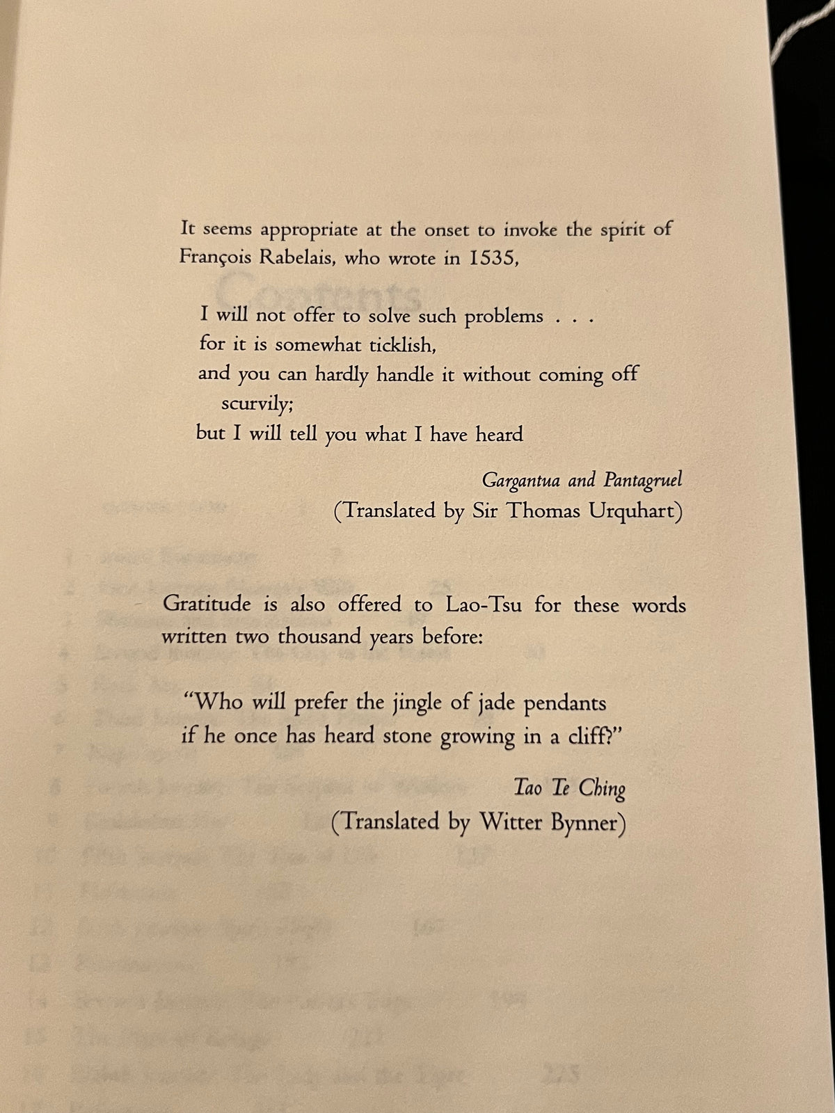 A printed page showing translated philosophical and literary texts on an off-white paper background, photographed against a dark surface.