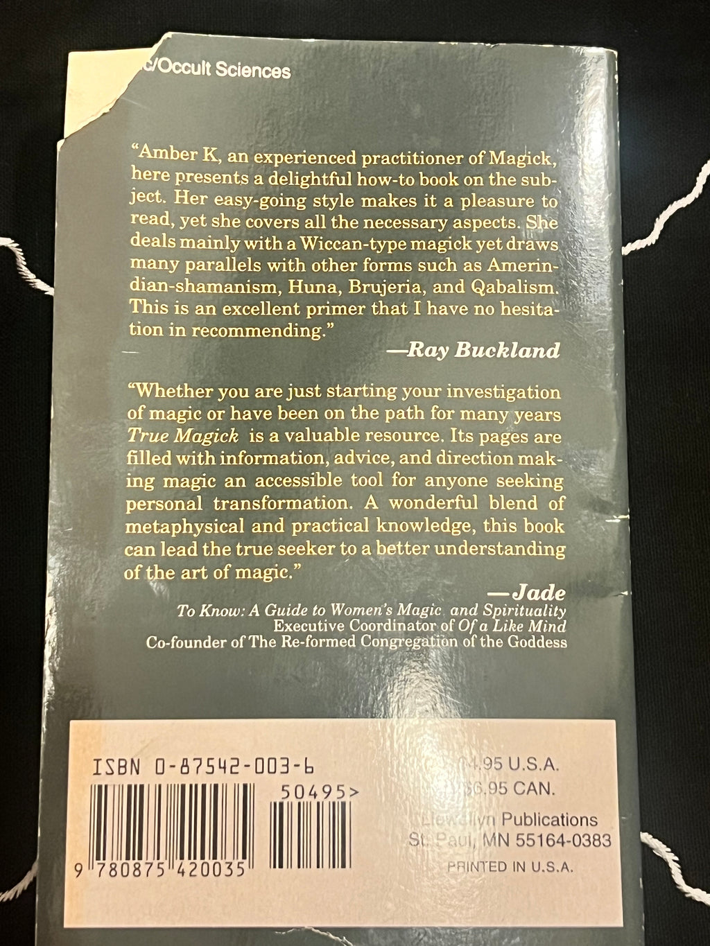 Back cover of a book titled True Magick: A Guide to Women's Magic and Spirituality, showing a beige review section, barcode, and publisher text on a dark green cover.