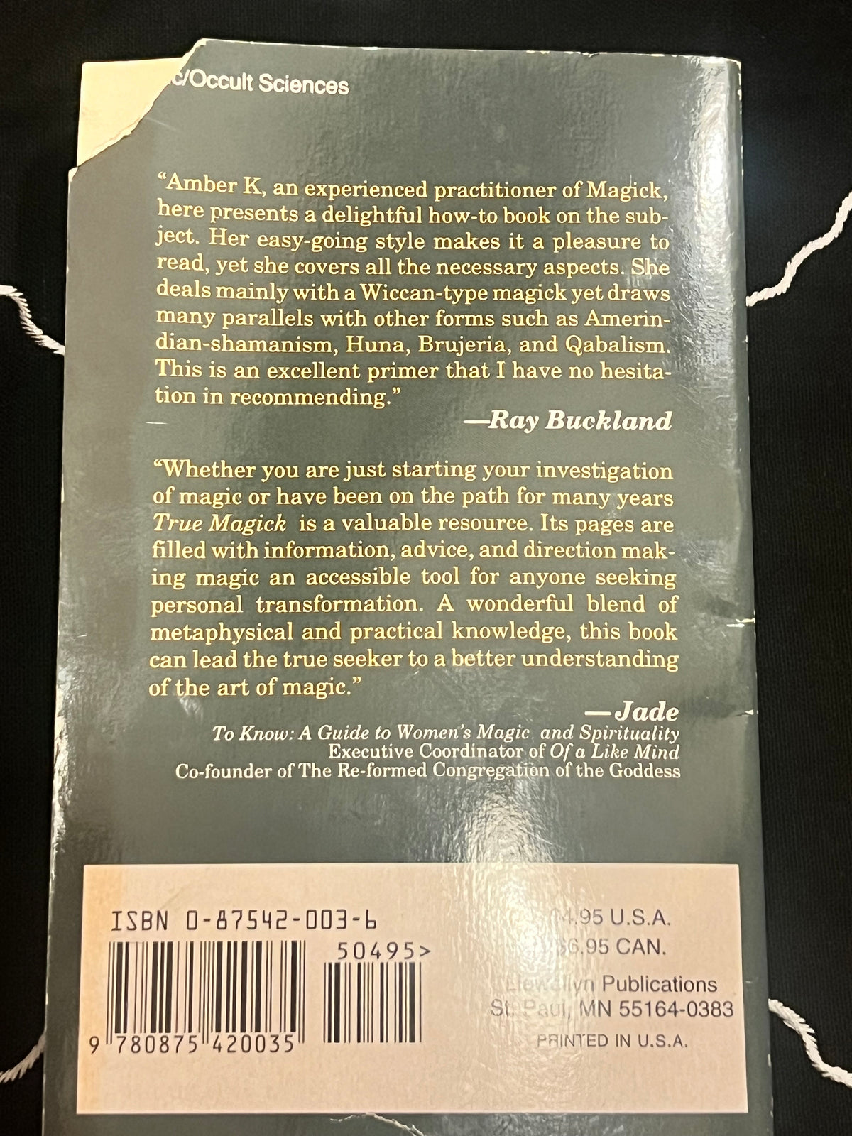 Back cover of a book titled True Magick: A Guide to Women's Magic and Spirituality, showing a beige review section, barcode, and publisher text on a dark green cover.