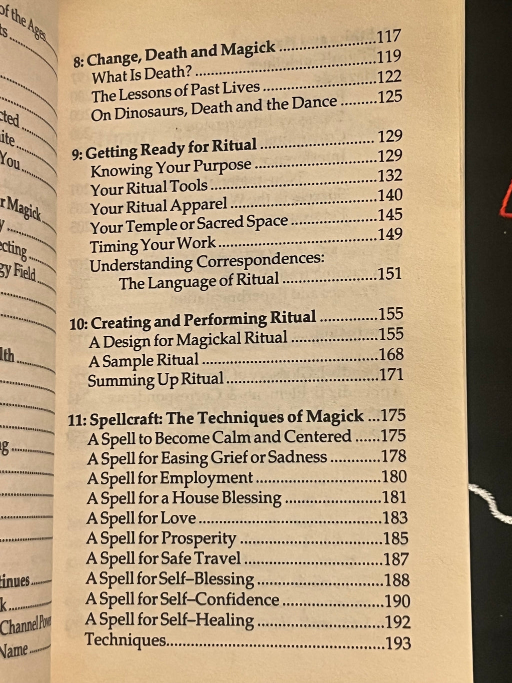 A close-up of an open book showing printed table-of-contents text from Chapter 8 to Chapter 11, with page numbers and headings visible.