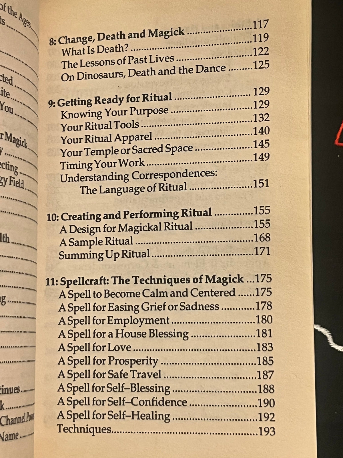 A close-up of an open book showing printed table-of-contents text from Chapter 8 to Chapter 11, with page numbers and headings visible.